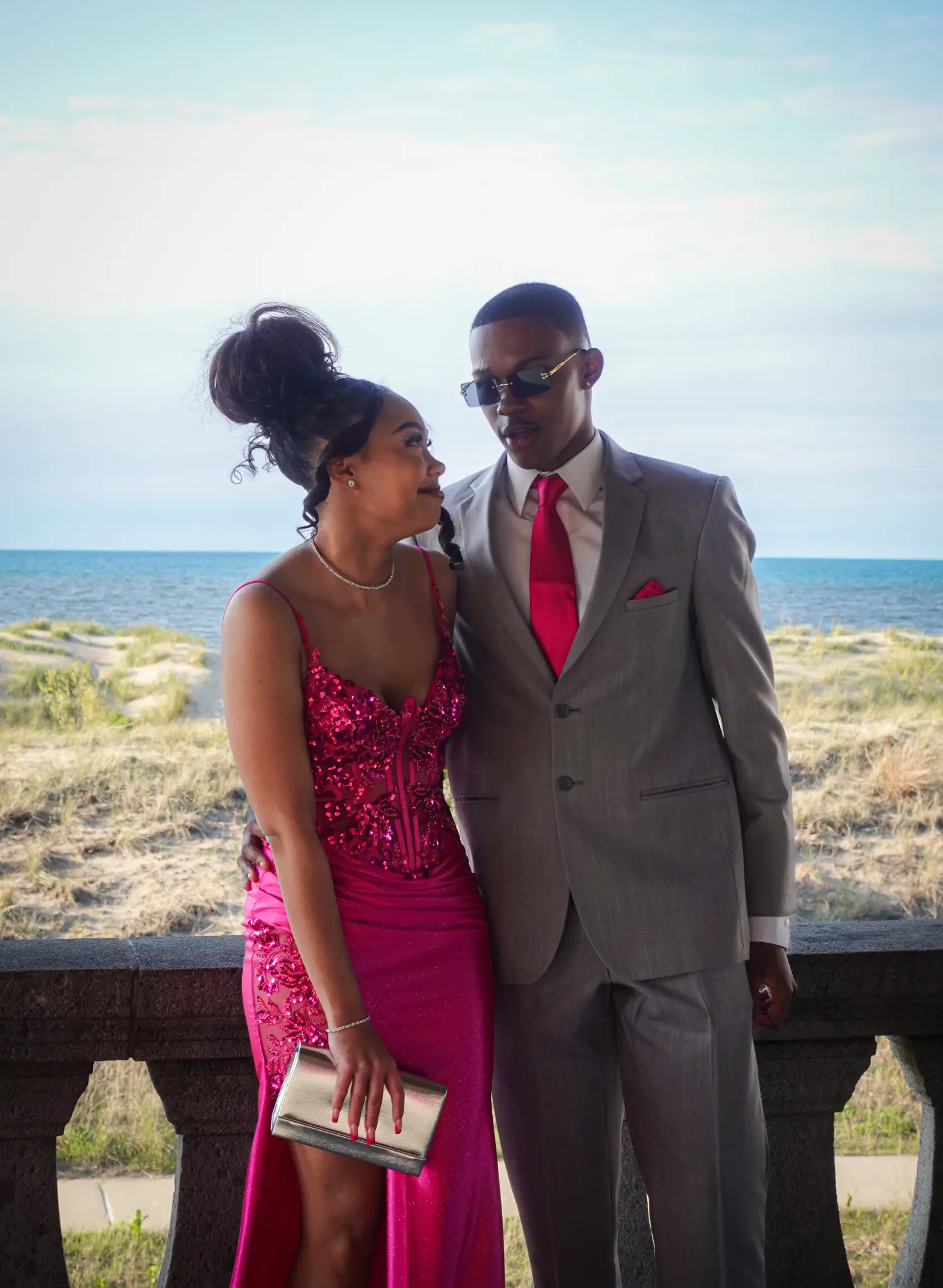 Prom couple standing together near a beach and lake backdrop photographed by Isabel Schilling Photography in Northwest Indiana.